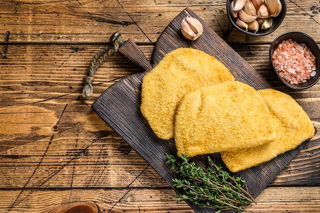 Escalopes de viande cordon bleu avec chapelure sur une planche en bois. fond en bois. Vue de dessus. Espace de copie.