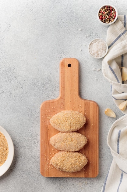 Escalopes de viande crues échouées sur une planche de bois