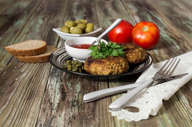 Escalopes de viande hachée et olives de sauce tomate de riz sur un gros plan de table en bois