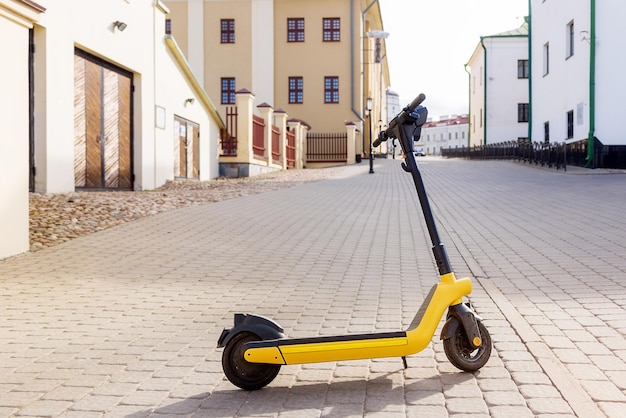 Escooter jaune dans la vieille ville un jour d'été par minute location copie espace