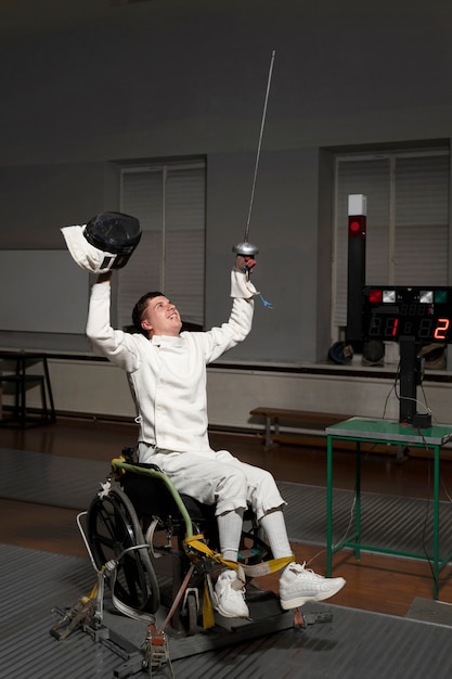 Photo escrimeur handicapé dans un équipement spécial assis dans un fauteuil roulant