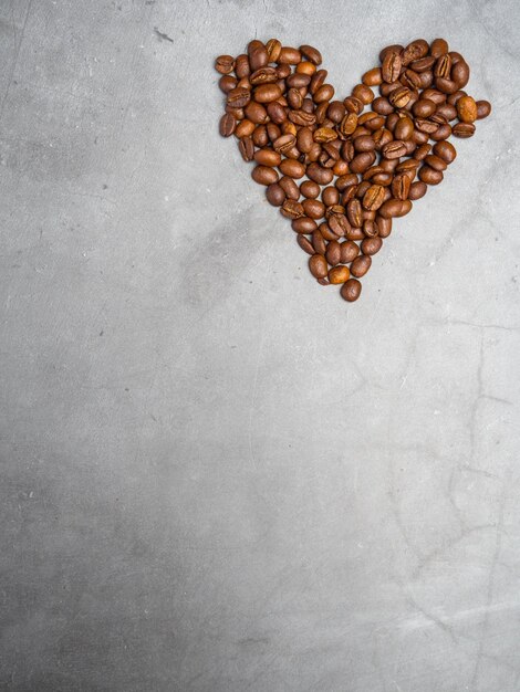 Espace de copie de grains de café en forme de coeur sur fond de béton