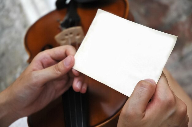 Espace de copie de papier ordinaire vierge blanc tenu par deux mains d'un joueur de violon