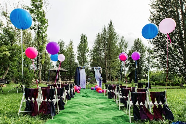 Espace décoré en plein air pour la cérémonie de mariage avec une arche en bois décorée de fleurs