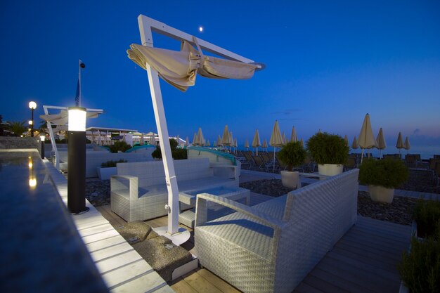 Espace salon sur les chaises longues de plage parasols en soirée au coucher du soleil