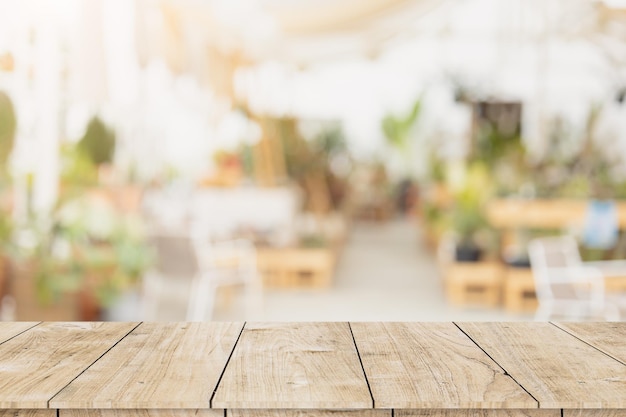 Espace table en bois avec café et restaurant flou blanc propre et confortable pour fond de montage de produits publicitaires