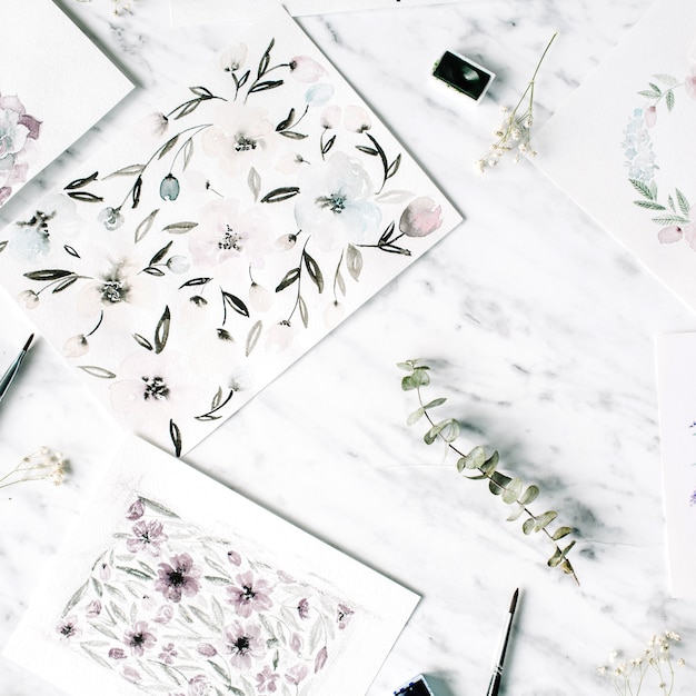 Photo espace de travail de l'artiste. peintures à l'aquarelle avec des cadres et des fleurs