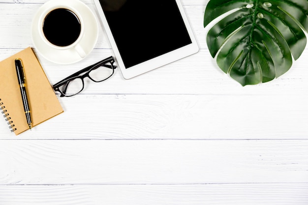 Espace de travail au bureau, bureau en bois blanc avec bloc-notes vierge et autres fournitures de bureau