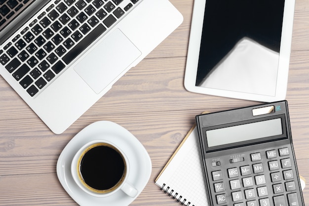 Espace de travail au bureau, bureau en bois avec ordinateur portable et vue de dessus de tasse à café