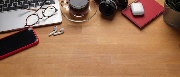 Espace de travail branché avec ordinateur portable, smartphone, fournitures et espace copie sur table en bois