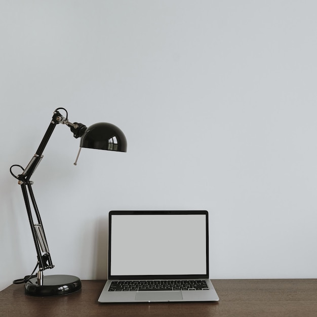 Photo espace de travail de bureau à domicile minimaliste avec une lampe d'ordinateur portable sur la table espace de copie en vue avant modèle en blanc