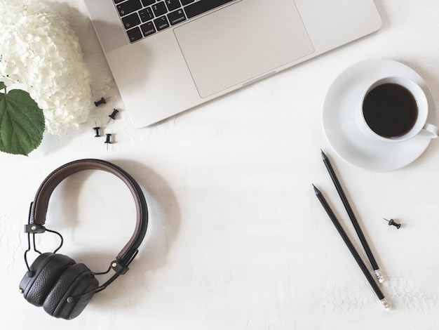 Espace de travail de bureau à domicile avec ordinateur portable, café noir en tasse