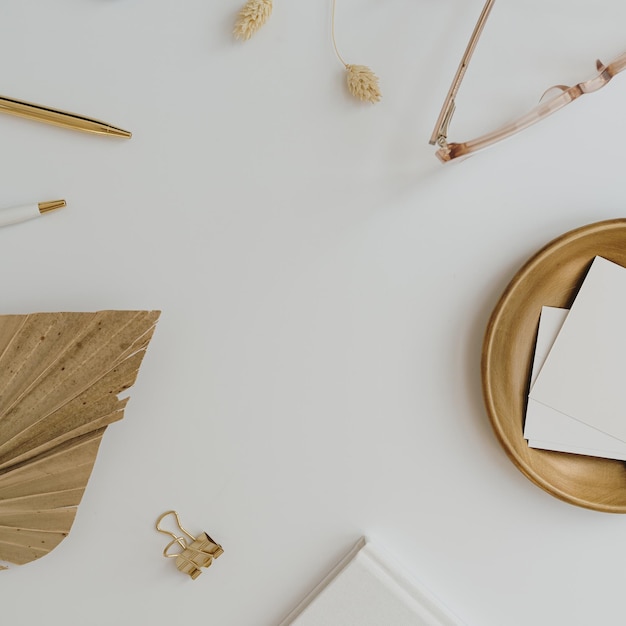 Espace de travail de bureau à domicile avec ordinateur portable feuille de carte de papier vierge avec fond lunettes papeterie sur table blanche Modèle de vue de dessus à plat