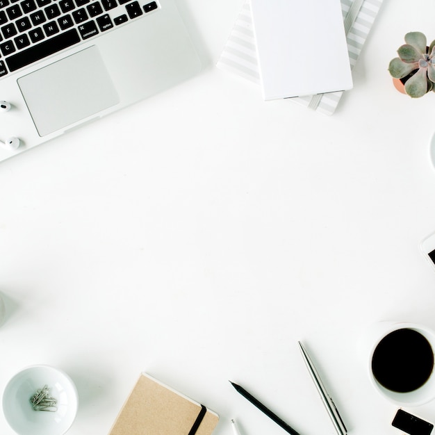 Espace de travail de bureau à domicile à plat avec ordinateur portable, agenda, succulentes et accessoires sur blanc