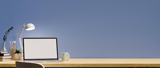 Espace de travail de bureau élégant avec ordinateur portable ouvert et espace de copie sur une table en bois moderne sur un mur bleu