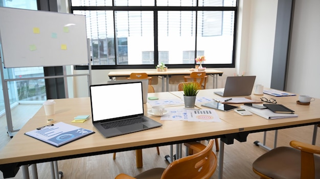 Espace de travail de bureau moderne à aire ouverte avec ordinateur portable et fournitures de bureau sur la table