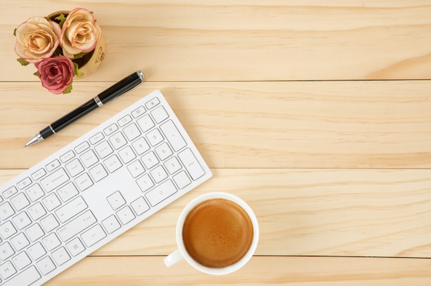 Espace de travail avec un clavier d'ordinateur blanc et une tasse de café