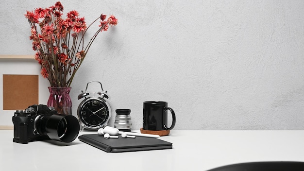 Espace de travail de concepteur créatif avec tasse à café pour tablette numérique et cadre photo sur tableau blanc