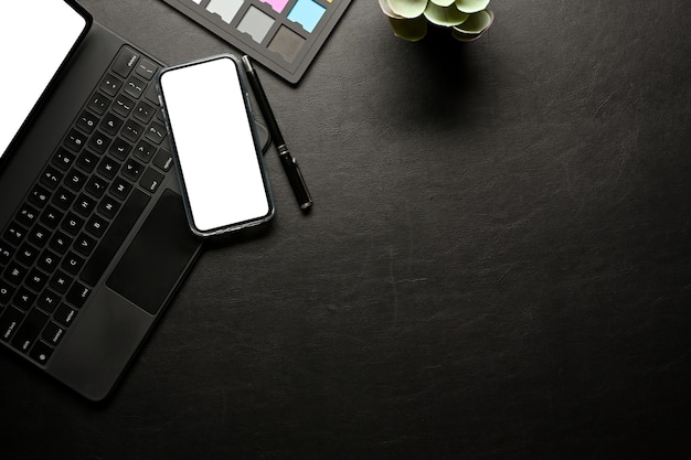 L'espace de travail créatif avec smartphone comprend des fournitures de clavier de tablette à écran de chemin de détourage et une vue de dessus de l'espace de copie