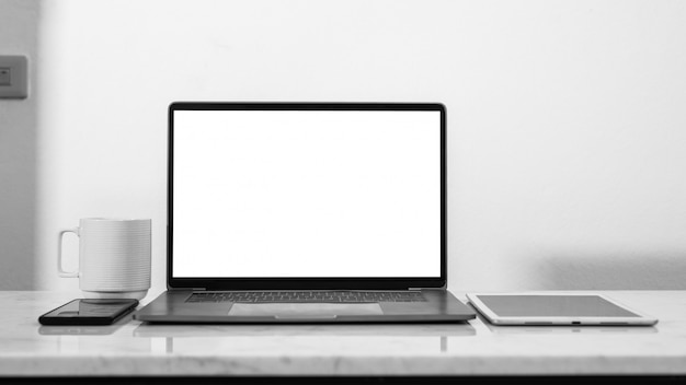 espace de travail élégant avec écran d'ordinateur portable vide blanc vide et tasse de café.