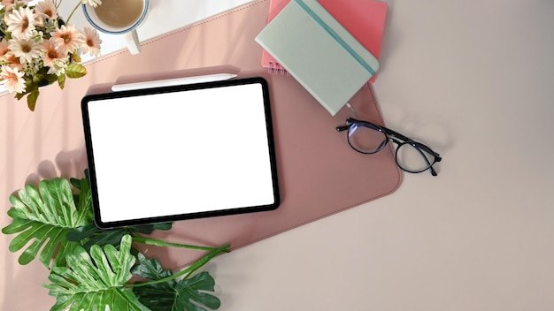 Espace de travail féminin avec tablette numérique verres tasse à café et cahier