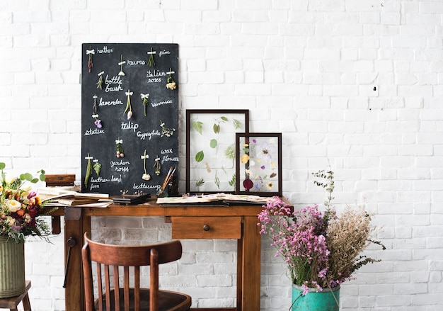 Espace de travail de fleuriste avec liste de noms de fleurs séchées sur tableau noir