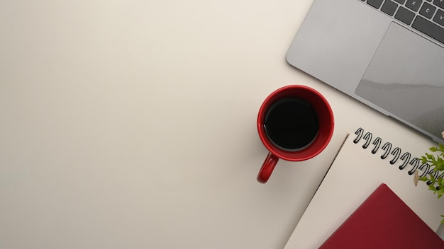 Espace de travail avec fournitures de bureau pour ordinateur portable et tasse à café sur fond blanc Vue de dessus