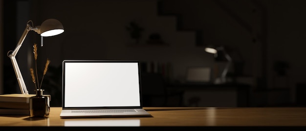 Espace de travail à la maison sombre et moderne la nuit avec la lumière de la maquette d'ordinateur portable pour ordinateur portable de lampe de table