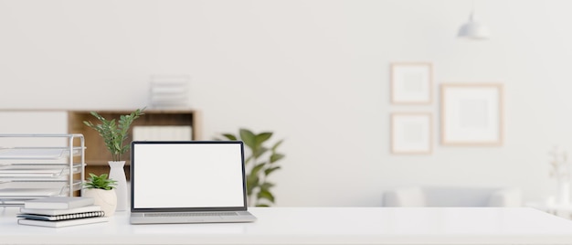 Espace de travail avec maquette d'ordinateur portable et espace de copie sur une table blanche dans une salle blanche moderne