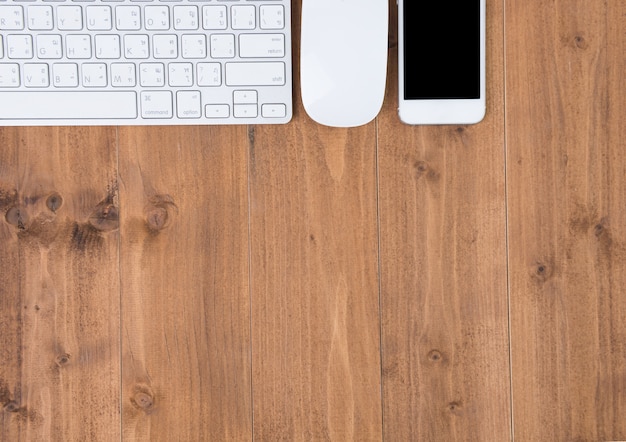 Espace de travail minimal, ordinateur et smartphone sur table en bois, vue de dessus