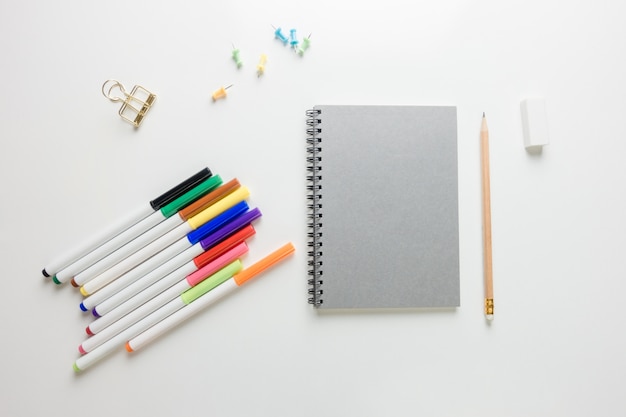 Espace de travail minimal - Photo créative de la table plate du bureau de l&#39;espace de travail avec un carnet de croquis et un crayon en bois sur un fond de copie fond blanc. Vue de dessus, photographie plate.