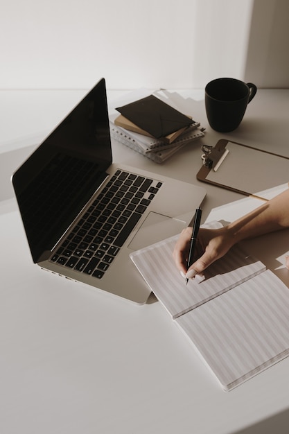 Espace de travail minimaliste de bureau à domicile avec ordinateur portable, tasse à café, presse-papiers