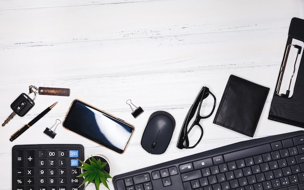 Espace de travail moderne avec des accessoires commerciaux sur fond blanc avec copyspace. Bureau de bureau. Bureau de travail avec clavier, fournitures de bureau, crayon, feuille verte sur table en bois. Photo créative à plat