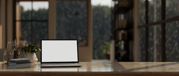 Un espace de travail moderne avec une maquette d'ordinateur portable et un espace de copie sur une table dans une pièce moderne un jour de pluie
