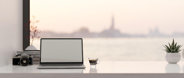 Espace de travail moderne avec ordinateur portable et décor sur table contre la fenêtre avec belle vue