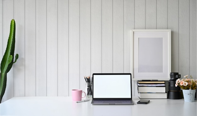 Espace de travail avec ordinateur portable à écran blanc.