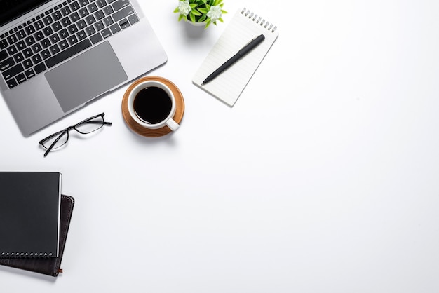 Espace de travail avec ordinateur portable tasse à café clavier dans un style plat. Fond blanc. Vue de dessus.