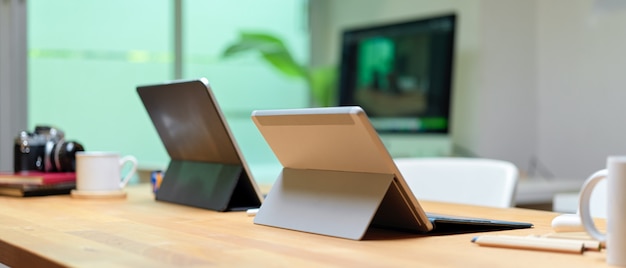 Espace de travail portable avec tablettes numériques et fournitures de bureau sur une table de travail en bois
