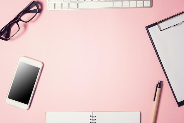 Photo espace de travail avec table de bureau avec beaucoup de choses dessus.