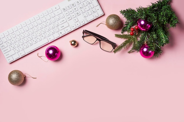 Espace de travail de table féminin élégant avec des décorations de Noël et des branches de sapin sur fond rose Vue de dessus à plat copiez l'espace