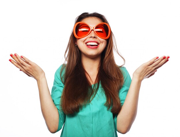 Espiègle jeune femme avec des lunettes de fête. Prêt pour le bon temps.