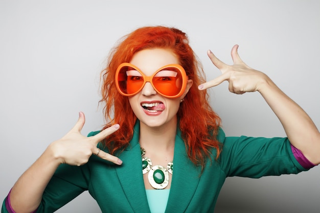 Espiègles jeunes femmes tenant une lunettes de fête.