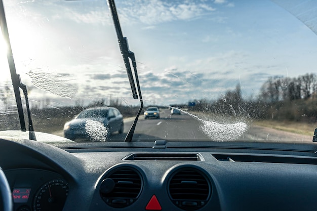 Les essuie-glaces de voiture nettoient les pare-brise lors de la conduite par temps ensoleillé