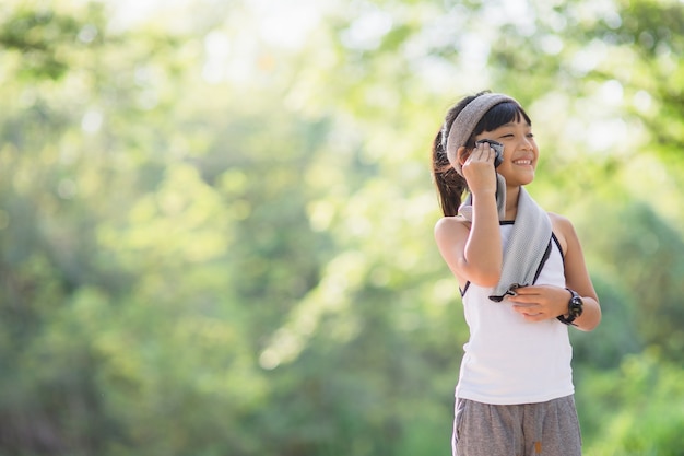 Essuyer la sueur des enfants jogger après l'entraînement. enfants faisant de l'exercice dans le parc de la ville à l'extérieur.