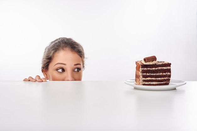 C'est une amoureuse du chocolat Prise de vue en studio d'une jolie jeune femme tentée par quelque chose de sucré