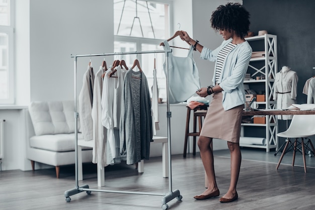 Est-ce assez bon ? Toute la longueur d'une jeune femme africaine séduisante regardant une chemise sans manches