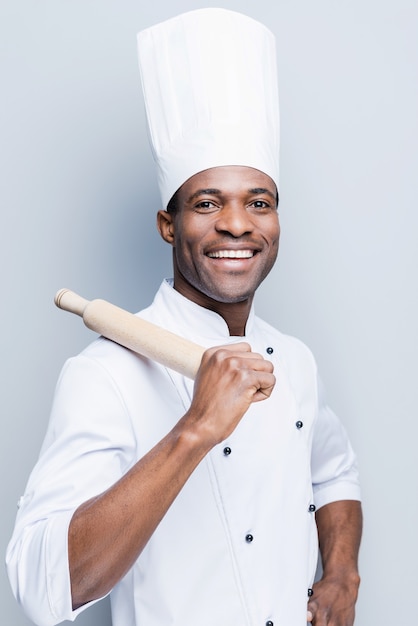 c'est un champion en cuisine. joyeux jeune chef africain en uniforme blanc