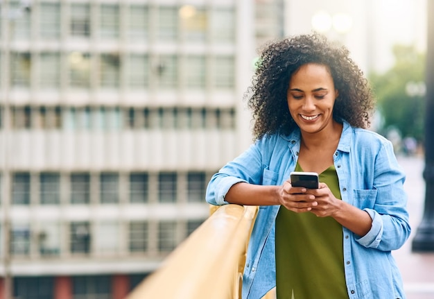 C'est l'endroit où bien se rencontrer Photo d'une jeune femme utilisant son téléphone portable en ville