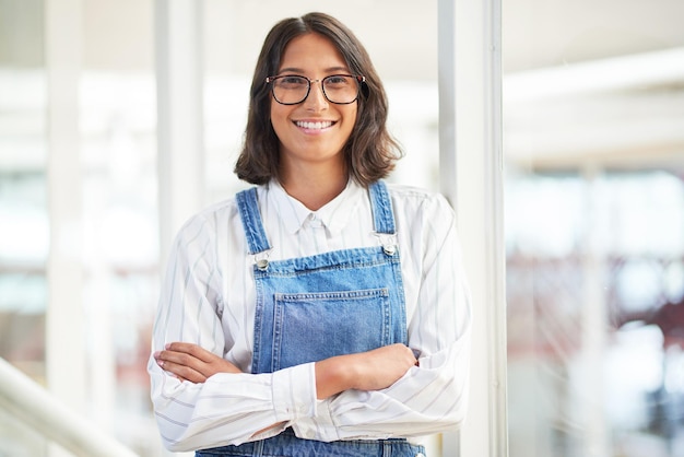 C'est l'entreprise la plus cool pour laquelle travailler Portrait d'une jeune femme d'affaires confiante travaillant dans un bureau moderne