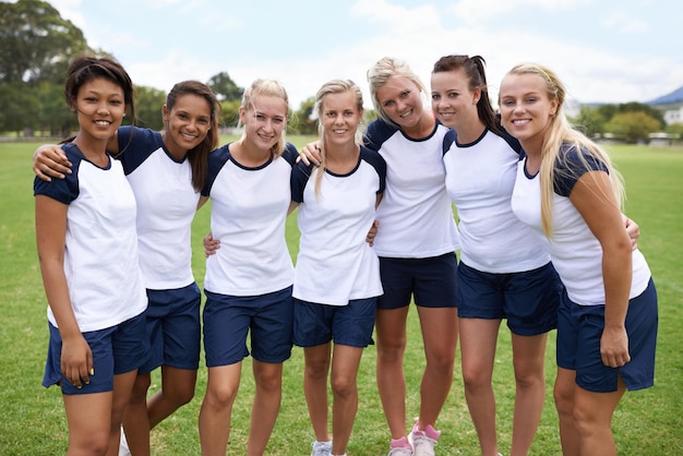 C'est une équipe dynamique Une équipe sportive composée uniquement de filles se tenant ensemble sur le terrain